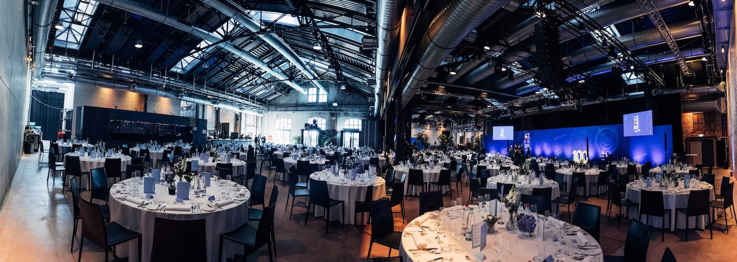 Festlich gedeckter Speisesaal der BANSBACH Jubiläumsgala Festlich gedeckter Speisesaal bei der 100 Jahre BANSBACH Kundengala in den Wagenhallen Stuttgart mit Blick auf die Bühne