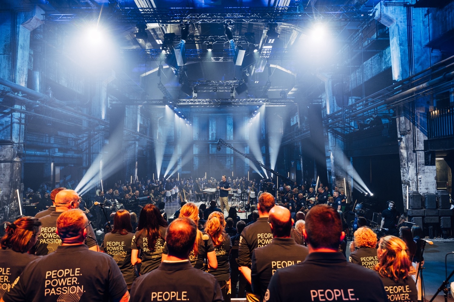 FEINMETALL Mitarbeiter performen live auf der Bühne Bühne mit Publikum beim FEINMETALL Jubiläumsevent während der Live-Performance des eigenen Firmensongs